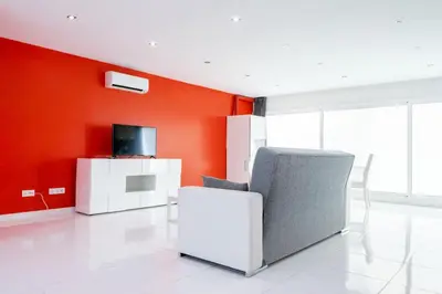a living room with a chair and a tv at VILLA 5 PLAYA A 2 MINUTOS in Castelldefels