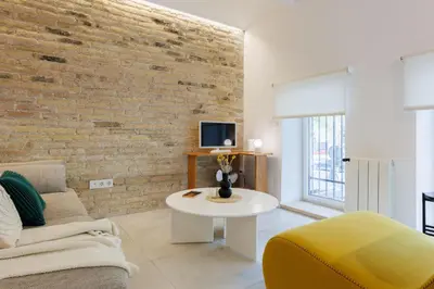 a living room with a brick wall and a couch and a table at Stylish Apartment near Plaça España in Barcelona