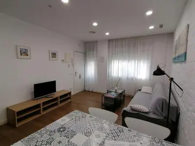 a living room with a couch and a table at Apartamento PB 30min Sagrada Familia, 10 min playa in Badalona