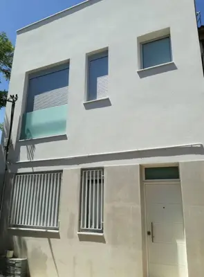 a white building with a door and windows at Apartamento PB 30min Sagrada Familia, 10 min playa in Badalona