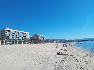 a group of people laying on the beach at Apartamento PB 30min Sagrada Familia, 10 min playa in Badalona