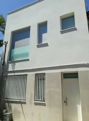 a white building with a door and windows at Apartamento P1 30min Sagrada Familia, 10 min playa in Badalona
