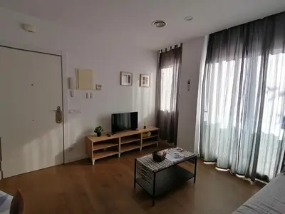 a living room with a television and a table at Apartamento P1 30min Sagrada Familia, 10 min playa in Badalona