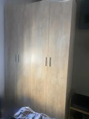 a wooden cabinet with two doors in a room at Cozy apartament in Barcelona