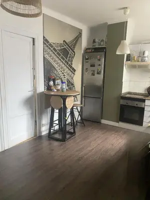 a kitchen with a small table and a refrigerator at Cozy apartament in Barcelona