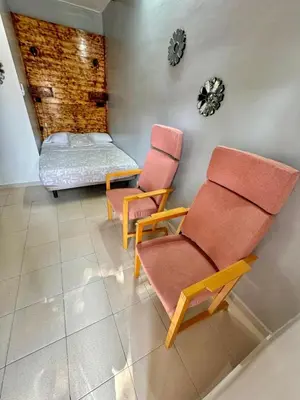 two chairs and a bed in a room at Nuevos Apartamentos frente al mar y a la playa in Castelldefels