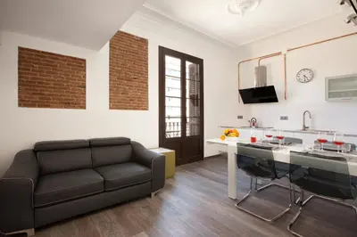 a living room with a couch and a kitchen at AB Paral·lel Spacious Apartments in Barcelona
