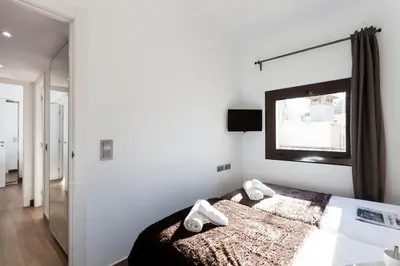 a bedroom with a bed and a flat screen tv at AB Paral·lel Spacious Apartments in Barcelona