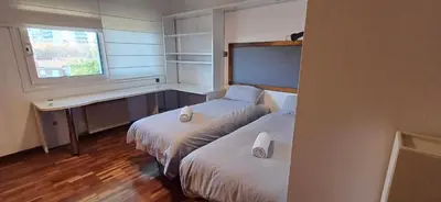 a hotel room with two beds and a window at MAGNÍFICA RESIDENCIA in Masnou