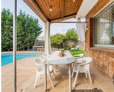a patio with a table and chairs and a pool at MAGNÍFICA RESIDENCIA in Masnou