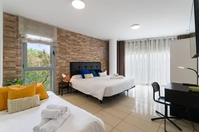 a bedroom with two beds and a flat screen tv at Fira Suites - Habitaciones privadas en Apartamento compartido in Hospitalet de Llobregat