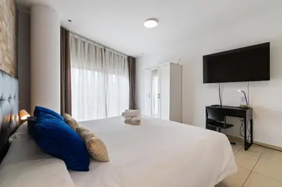 a bedroom with a large white bed with blue pillows at Fira Suites - Habitaciones privadas en Apartamento compartido in Hospitalet de Llobregat