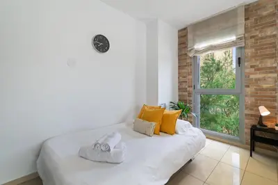 a white bed in a room with a window at Fira Suites - Habitaciones privadas en Apartamento compartido in Hospitalet de Llobregat