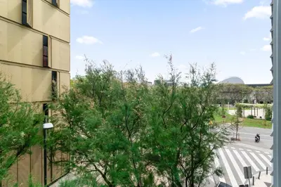 a tree in front of a building and a street at Fira Suites - Habitaciones privadas en Apartamento compartido in Hospitalet de Llobregat
