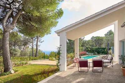 a patio with a table and chairs next to a pool at Casa Brisa Boutique Guest House - Gay Men Only in Sant Pere de Ribes