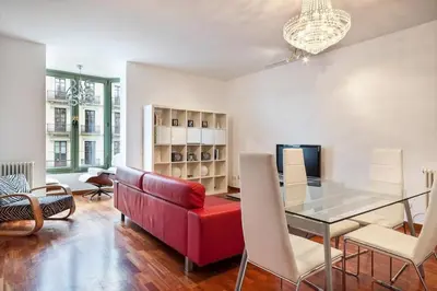 a living room with a red couch and a glass table at Canela Homes BARCELONA UNIVERSITAT in Barcelona