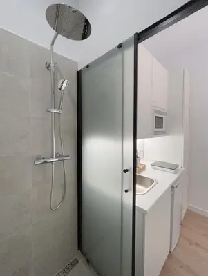 a shower with a glass door in a bathroom at SD Habitación céntrica con baño y Kitchenette in Terrassa