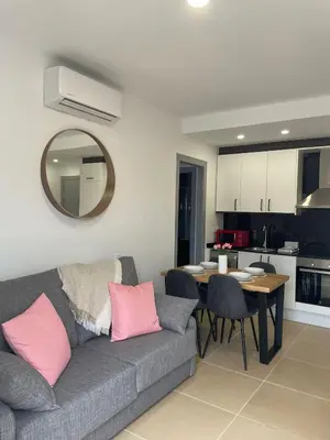 a living room with a couch and a table and a kitchen at Luminoso dúplex con parking in Terrassa