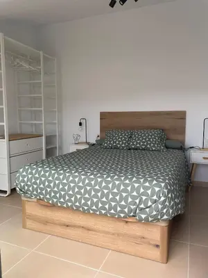 a bedroom with a bed with a wooden bed frame at Luminoso dúplex con parking in Terrassa