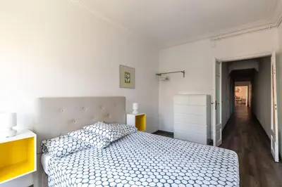 a white bedroom with a bed and a hallway at Centric and spacious, excellent for families in Barcelona