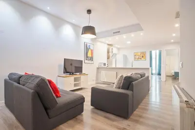 a living room with two chairs and a television at Barcelona Eixample in Barcelona