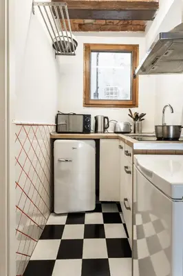a kitchen with a black and white checkered floor at Apartamento La Boqueria 4 in Barcelona