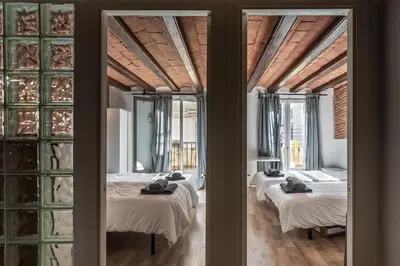 two beds in a room with glass windows at Apartamento La Boqueria 4 in Barcelona
