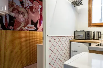 a kitchen with a yellow and red tiled wall at Apartamento La Boqueria 4 in Barcelona