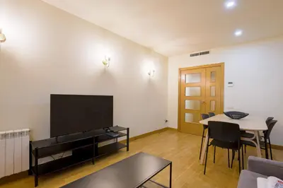 a living room with a flat screen tv and a table at Alcam Gold in Barcelona