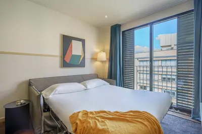 a bedroom with a bed and a large window at Aspasios Diagonal Art Apartments in Barcelona