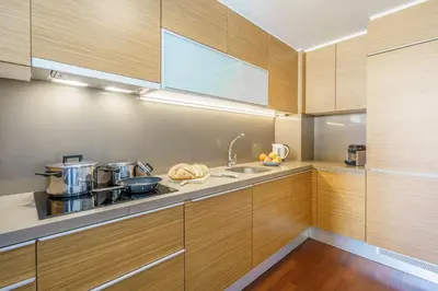 a kitchen with wooden cabinets and a sink at Aspasios Diagonal Art Apartments in Barcelona