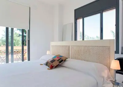 a bedroom with a white bed with a pillow on it at Tu Casa en Barcelona in Sant Cugat del Vallès