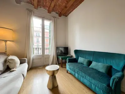 a living room with a blue couch and a window at Stay U-nique Apartment Arago II in Barcelona