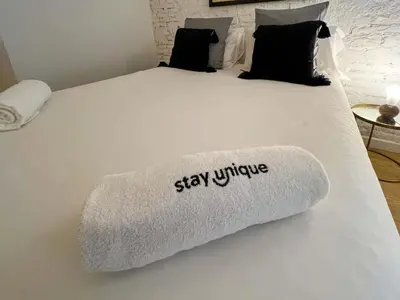 a bed with a white blanket with the words stay unique at Stay U-nique Apartment Arago II in Barcelona