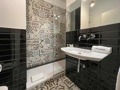 a bathroom with a sink and black and white tiles at Stay U-nique Apartment Arago II in Barcelona