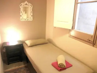 a small room with a bed and a window at Piquer con Terraza in Barcelona