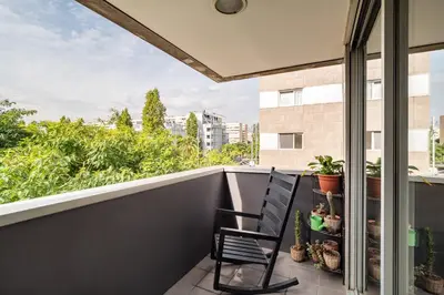 a black chair sitting on a balcony with a view at MERCE APARTMENT FORUM BARCELONA in Sant Adria de Besos
