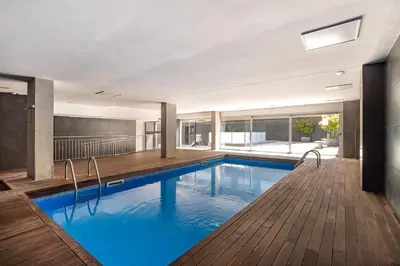 a swimming pool with blue water in a building at MERCE APARTMENT FORUM BARCELONA in Sant Adria de Besos