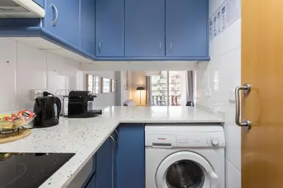 a kitchen with blue cabinets and a washing machine at The Best Barcelona in Barcelona