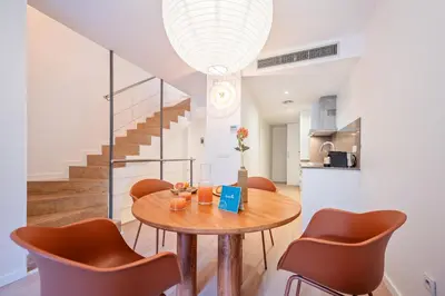 a kitchen and dining room with a table and chairs at Sweett - Casa Girona in Barcelona