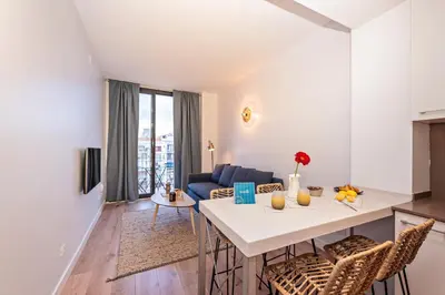 a kitchen and living room with a table and chairs at Sweett - Casa Girona in Barcelona