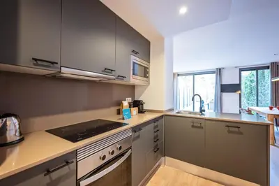 a kitchen with gray cabinets and a counter top at Sweett - Casa Girona in Barcelona