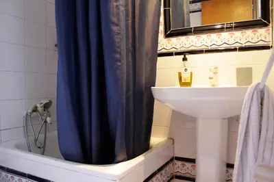 a bathroom with a sink and a blue shower curtain at Quiet apartment! Sagrada Familia! in Barcelona