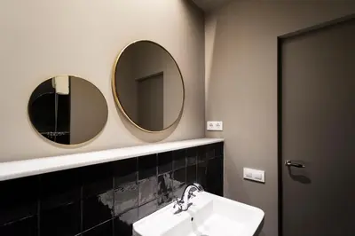 a bathroom with two mirrors and a sink at Hostal Porxos Garden in Barcelona