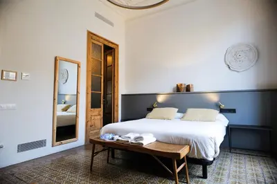 a bedroom with a bed and a mirror and a table at Hostal Porxos Garden in Barcelona