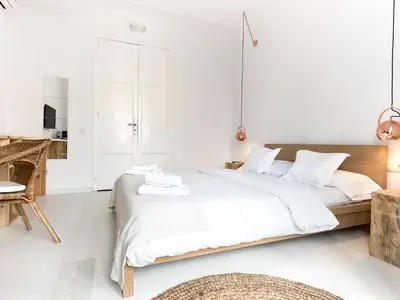 a white bedroom with a large bed and a table at Bruc & Bruc in Barcelona