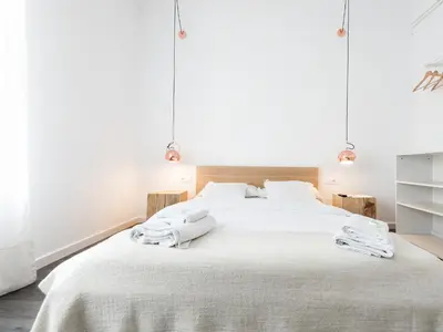 a bedroom with a large white bed with towels on it at Bruc & Bruc in Barcelona