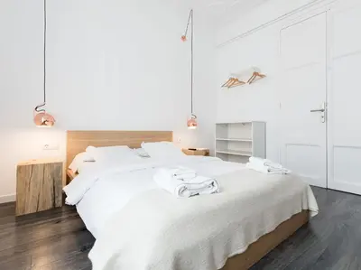 a white bedroom with a large bed with towels on it at Bruc & Bruc in Barcelona