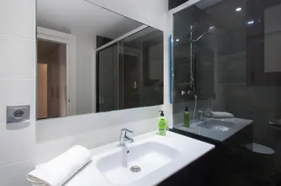 a bathroom with a white sink and a mirror at Autèntic Eixample Barcelona in Barcelona