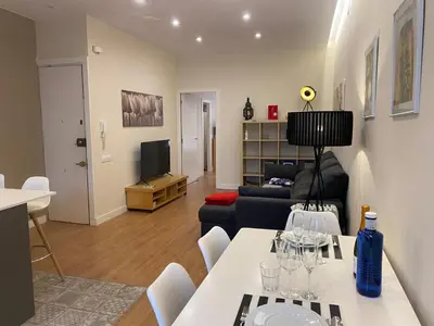 a living room with a couch and a table with wine glasses at Spatious luxe apartment Paseo de Gracia Diagonal in Barcelona